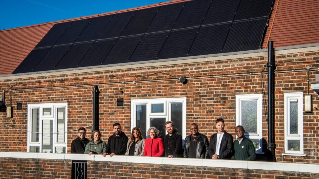 members of hackney council stand in front of a home with solar panels