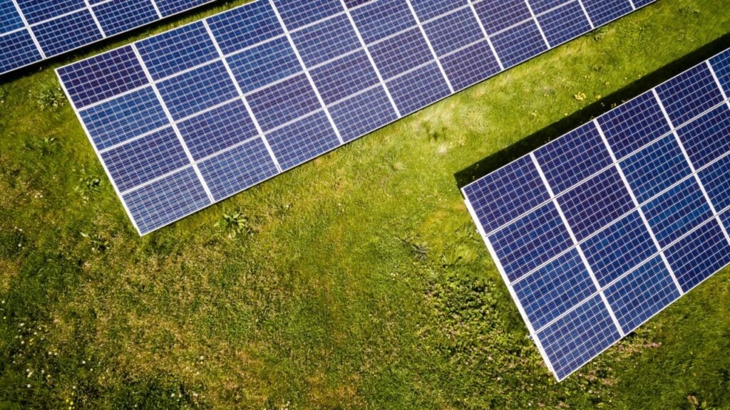 Two solar panels on a grassy field shot from above