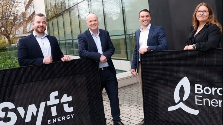 executives from bord gais and swyft shake hands while holding signs with company logos