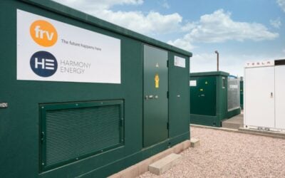 A dark green battery energy storage system, outside, under a blue sky