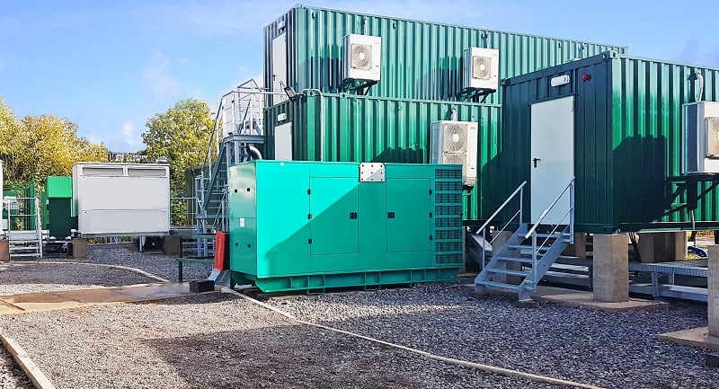 Green BESS units stacked on top of each other