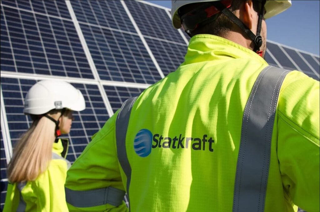 two engineers in Stakraft branded high vis jackets stand by a solar panel